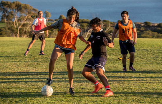 Students playing soccer on alumni park